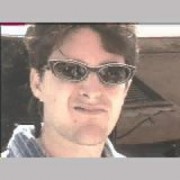 Dark-haired man in sunglasses making a face